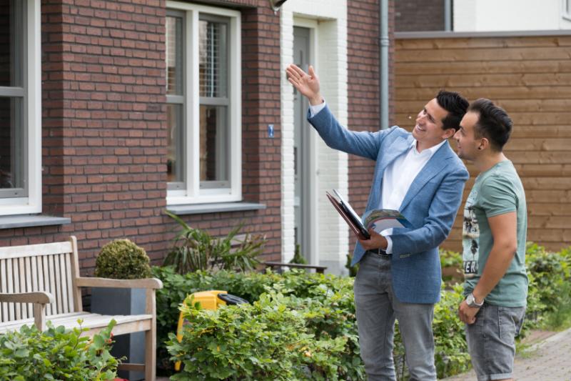 Hartger met klant voor woning